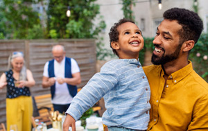 Smiling son and father with grandparents in the background