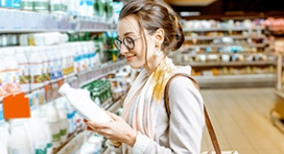 Woman buying milk in the supermarket